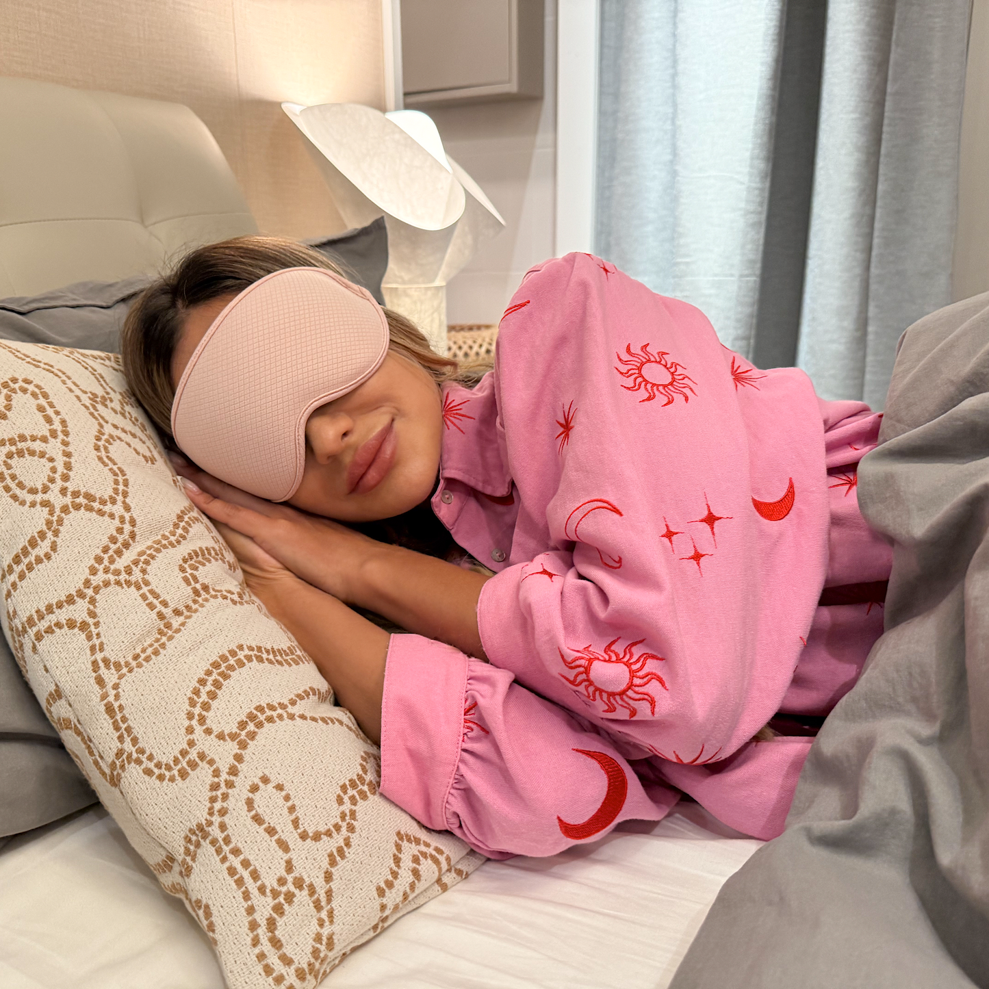 Woman sleeping in pink LEVIQUE 3D sleep mask, soft and comfortable for bedtime relaxation and deep rest.